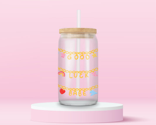 Glass tumbler with charm chains spelling good luck babe with colorful lucky symbols.