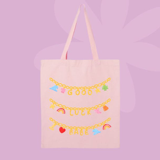 Canvas tote bag with charm bracelet style design spelling good luck babe.