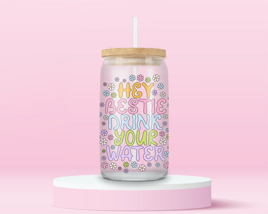 Glass tumbler with colorful text that reads hey bestie drink your water surrounded by flowers.