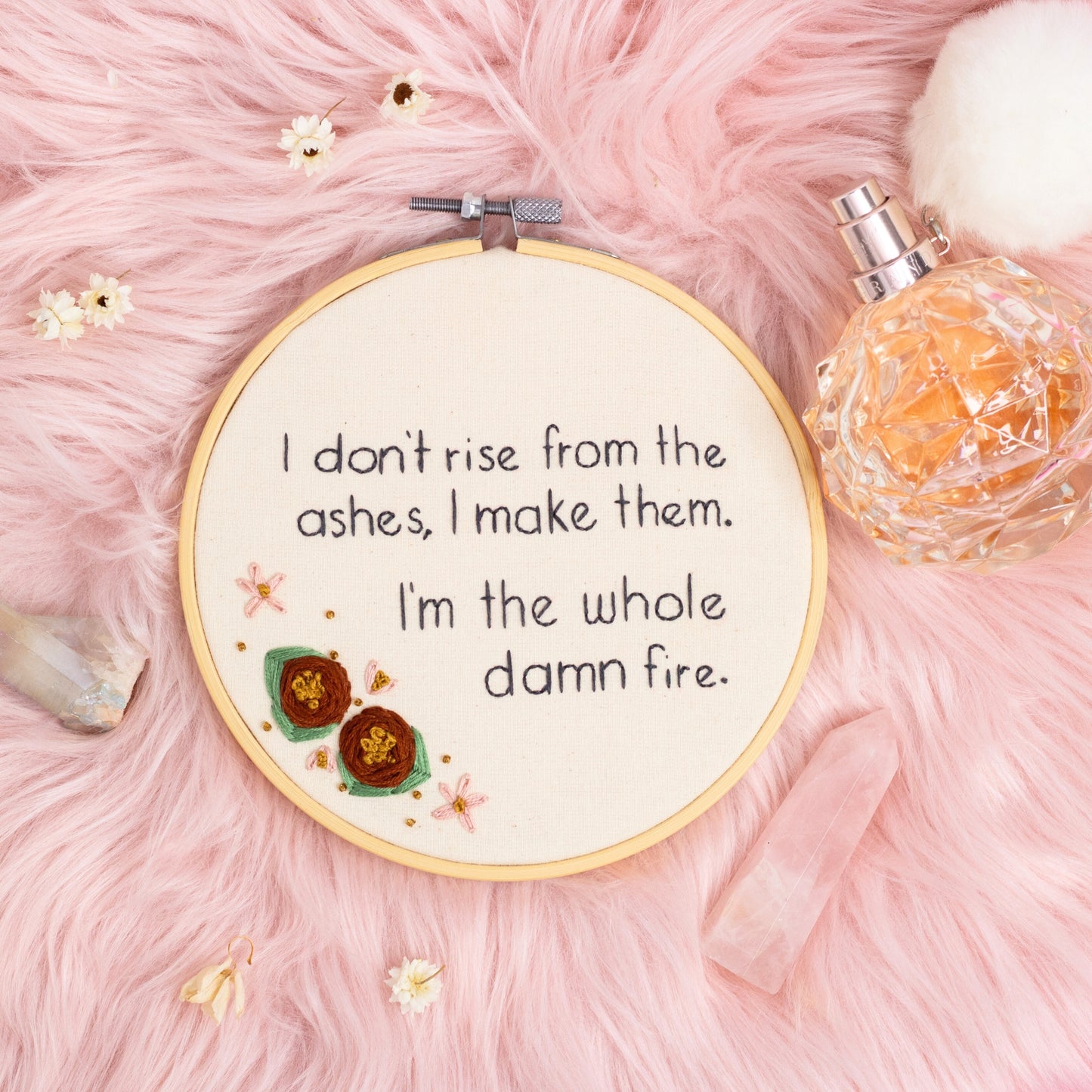 I don’t rise from the ashes I make them I’m the whole damn fire hand embroidered quote hoop with floral detail on pink background
