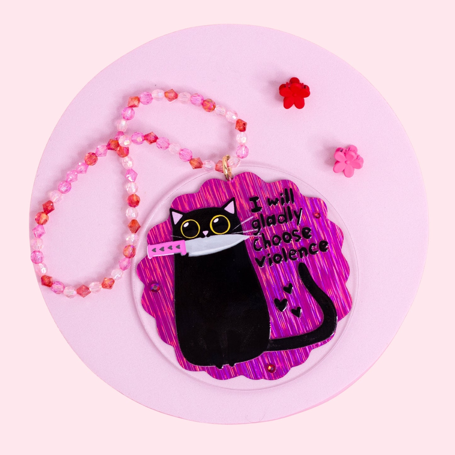 funny black cat holding knife acrylic car charm with purple holographic background and pink beaded hanger