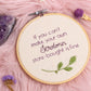 Close up of serotonin quote embroidery hoop with purple lettering and green leaf embroidery in wooden hoop