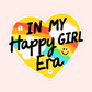 Yellow heart sticker with rainbow, clouds, smiley face and text that reads “In My Happy Girl Era.”