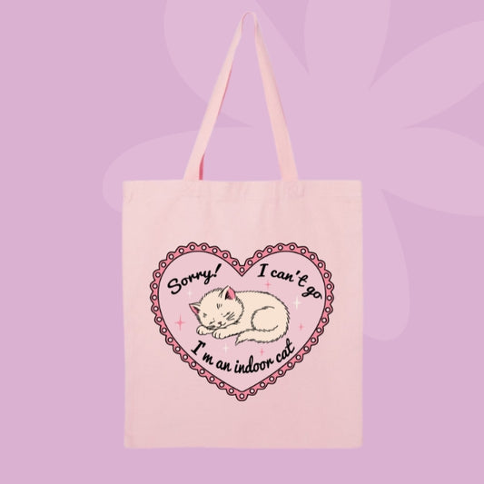 Pink canvas tote bag featuring a sleepy kitten inside a pink heart with text that says Sorry! I can’t go, I’m an indoor cat.