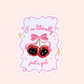 Sticker with two black cat faces inside red cherries, tied with a pink bow, and the words “I’m literally just a girl.”