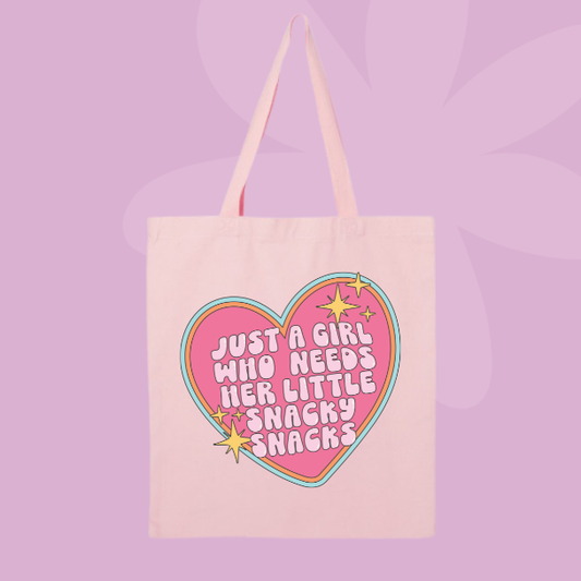 Funny snack themed tote bag with pink heart graphic and text reading just a girl who needs her little snacky snacks.