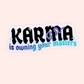 Sticker with bold text that says “Karma is owning your masters” with sparkles and a purple snake design.