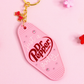 pink motel style keychain with “just a Dr Pepper girly” text, rhinestones and bow charm on pink background