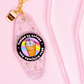 close up of clear glitter keychain with rainbow coffee cup design, rhinestones and gold hardware on soft pink background