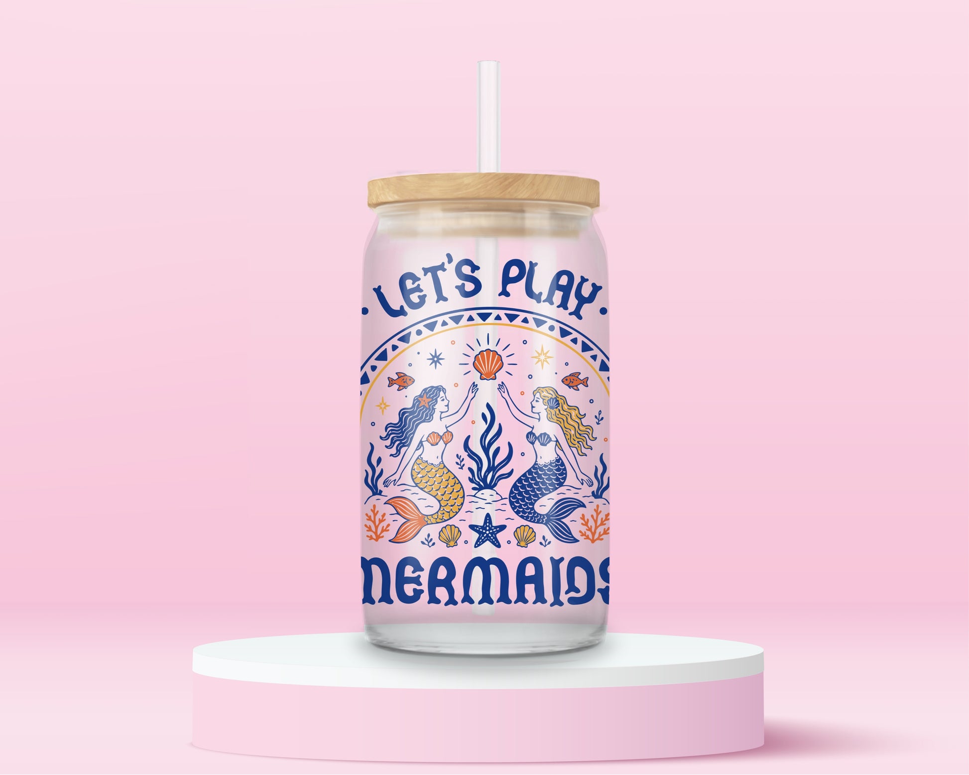 Glass can tumbler with bamboo lid and glass straw featuring retro-inspired mermaids, seashells, starfish, coral, fish, and the words Let’s Play Mermaids on a pink background.