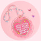 Little Snacky Snacks car charm with a pink heart design, retro lettering, sparkly details, and a pastel handmade beaded hanger.