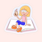 Lizzie McGuire-inspired blonde cartoon girl sitting on an open book holding an iced coffee with pink and orange details.