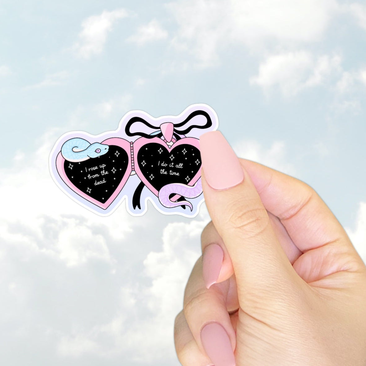 A pink and black heart-shaped locket sticker with a pastel snake and lyrics from Taylor Swift’s Look What You Made Me Do: “I rose up from the dead, I do it all the time.”