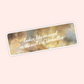 Rectangle lyric-inspired sticker with a cloudy painted background and the phrase “lookin’ like an angel on the walls of Versailles.”