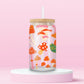 Glass tumbler with colorful whimsical mushrooms in a playful forest inspired pattern.