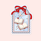 Cute bookish sticker with open books, stars, a crescent moon, arrow, scalloped blue frame, and a red bow.