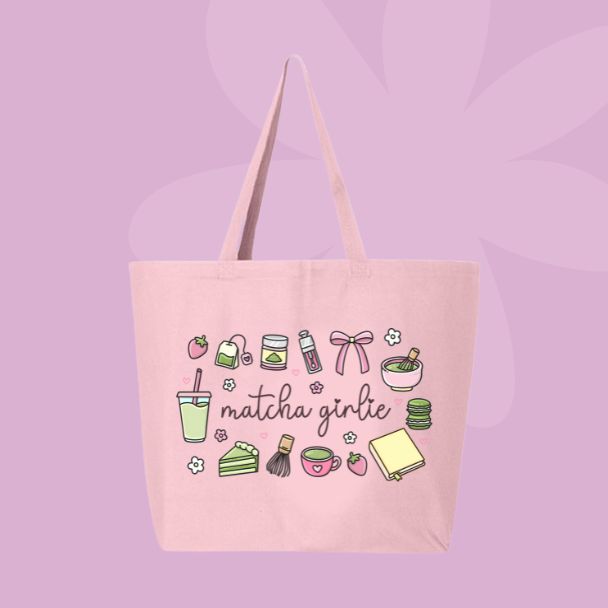 Large pink canvas tote bag featuring the words matcha girlie surrounded by matcha drinks, tea tins, bows, macarons, cake, flowers, and café-inspired doodles.