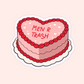 Pink heart shaped cake sticker with red piping and text that reads “Men R Trash.”