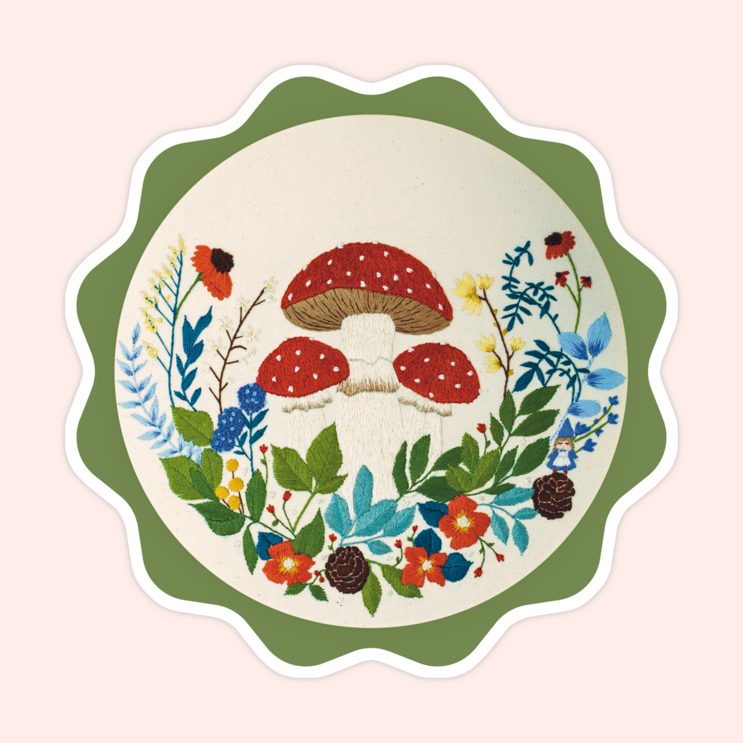 Sticker of original embroidery art featuring red mushrooms, wildflowers, leaves, pinecones, and whimsical woodland details.