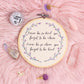 Never be so kind quote embroidery hoop wall art with purple flowers styled on pink background with crystals and disco ball