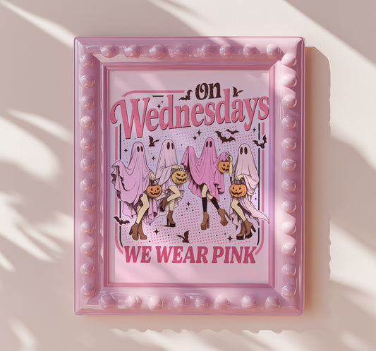 Four playful ghosts draped in pink sheets holding jack-o’-lanterns and wearing high heels, with the text “On Wednesdays We Wear Pink.”