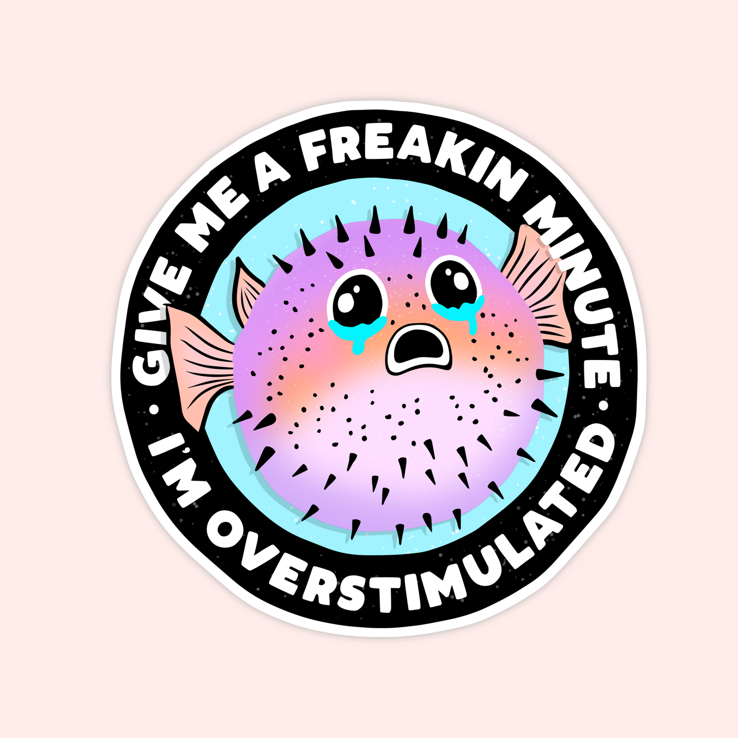Round sticker featuring a pastel pufferfish with teary eyes and the text "Give me a freakin minute I’m overstimulated."