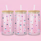 Glass cup with pastel pansies, navy blue hearts, and star sparkles on a soft pink background.