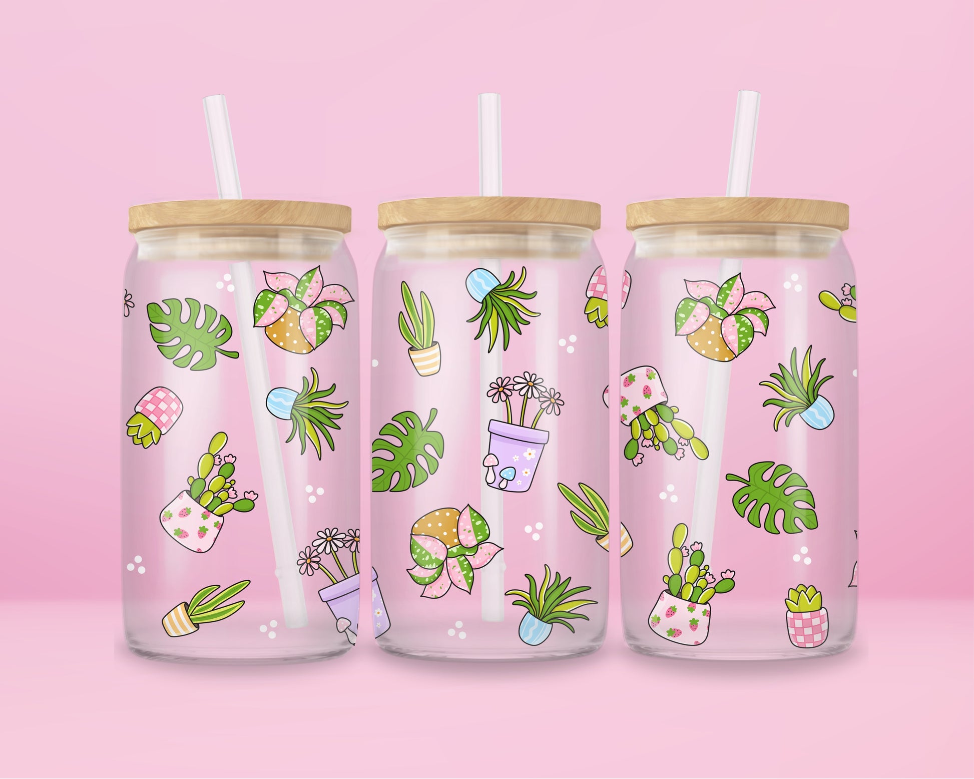Glass can tumbler with bamboo lid and glass straw featuring potted plants, leafy greens, daisies, cacti, and botanical illustrations on a pink background.