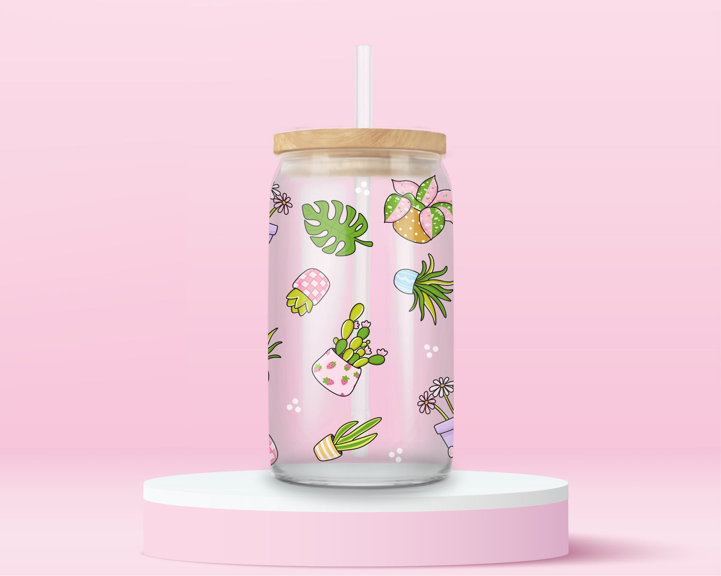 Glass can tumbler with bamboo lid and glass straw featuring potted plants, leafy greens, daisies, cacti, and botanical illustrations on a pink background.