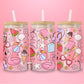 Glass can tumbler with bamboo lid and glass straw featuring a pink flamingo float, beach ball, watermelon, sunglasses, iced coffee, flowers, seashells, and ice cream on a pink background.