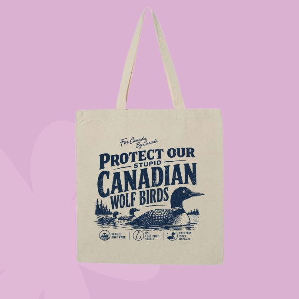 Beige canvas tote bag featuring navy vintage-style text that says Protect Our Stupid Canadian Wolf Birds with a loon and lake illustration.