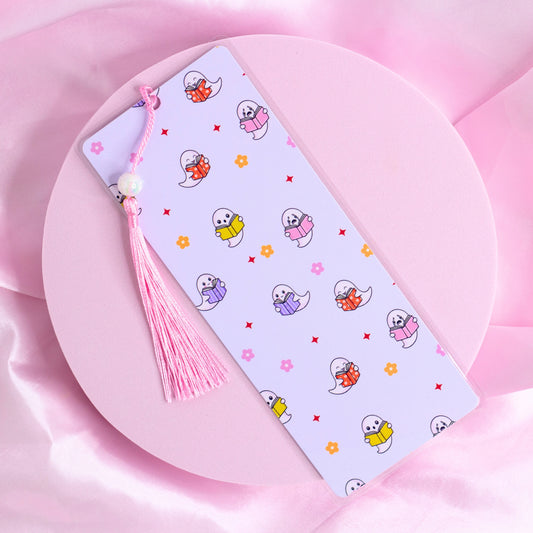 Lilac bookmark with colorful pastel ghosts holding books, surrounded by flowers and stars, with a pink tassel.
