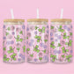 Glass can tumbler with bamboo lid and glass straw featuring pink roses, purple flowers, and green ivy leaves on a pink background.