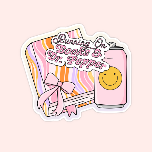 Striped book with a pink bow and a pink soda can with a smiley face that says "Running on Books & Dr. Pepper."