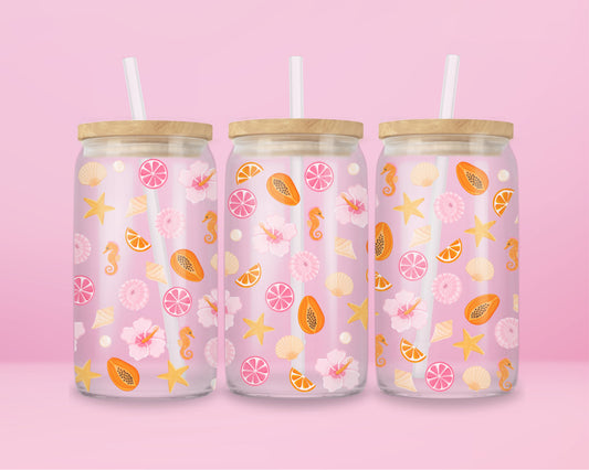 Glass can tumbler with bamboo lid and glass straw featuring seashells, starfish, citrus slices, hibiscus flowers, papaya, pearls, and seahorses on a pink background.