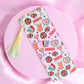 White bookmark with repeating disco balls, cocktails, corsets, and “Showgirl” text, finished with a pastel tassel.