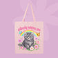 Pink canvas tote bag featuring a grumpy grey kitten, rainbow, flowers, butterflies, and pink text that says Silently Judging You.