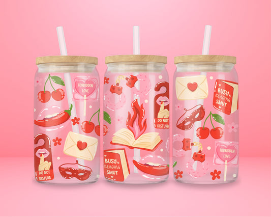 glass tumbler decorated with cherries, lips, masquerade masks, “Busy Reading Smut” book, and “Forbidden Love” signs.