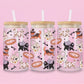 glass tumbler decorated with cats in costumes (witch hats, mummy wraps, spider capes), ghost tote bags, and fish bones.