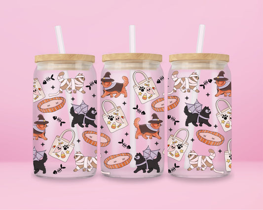 glass tumbler decorated with cats in costumes (witch hats, mummy wraps, spider capes), ghost tote bags, and fish bones.