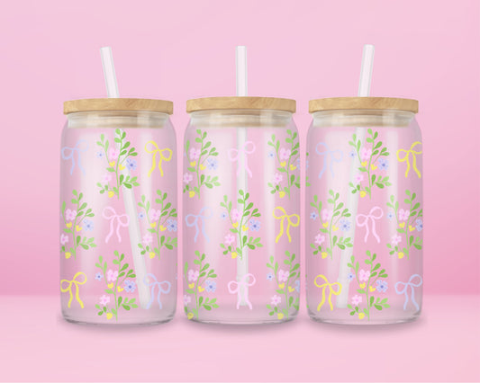 A pink glass cup with pastel-colored bows and dainty floral vines. Light, fresh, and blooming with springtime charm.