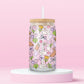 Pink glass tumbler with swans, bunnies, flowers, bows, and Easter eggs in a pastel spring pattern.