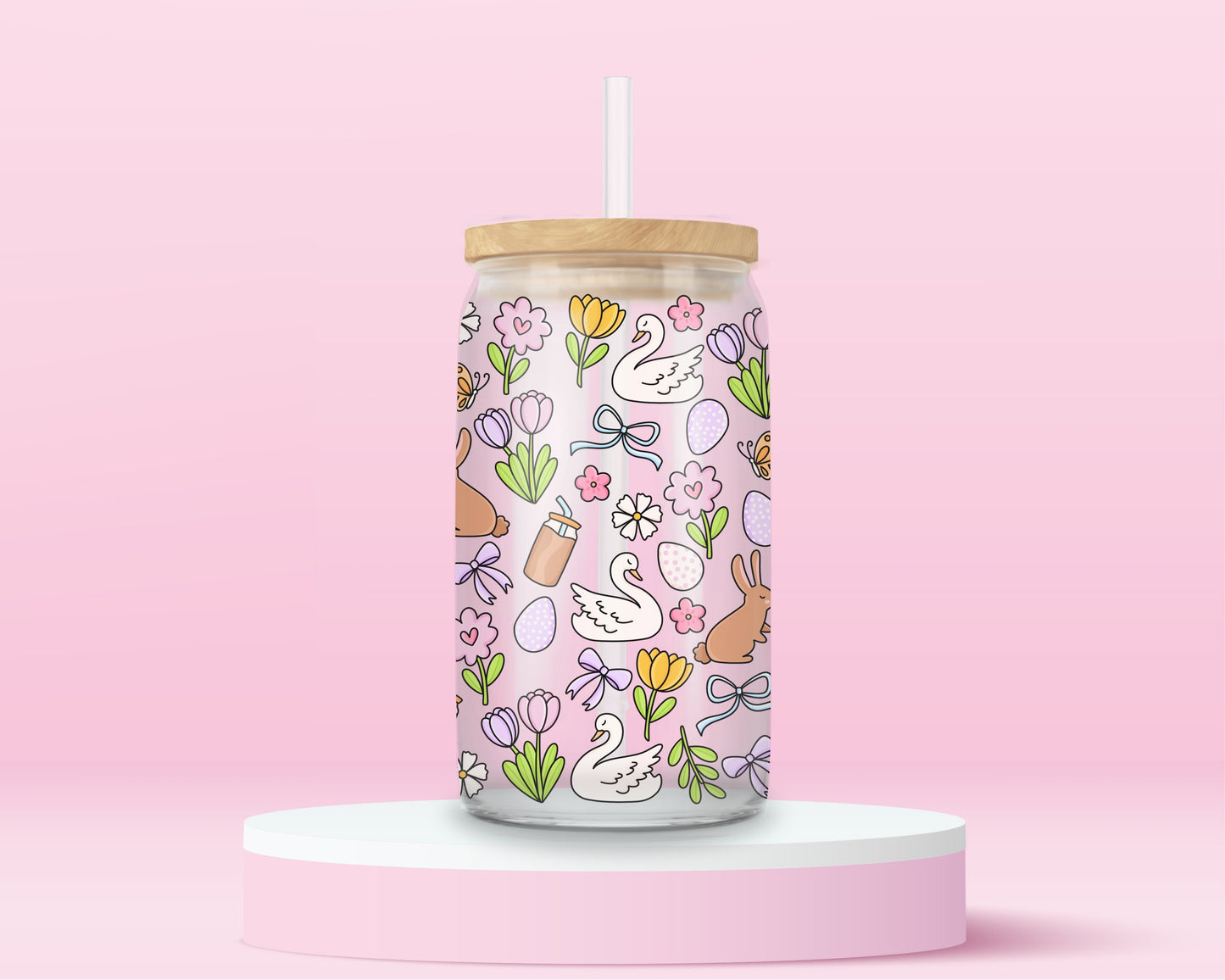 Pink glass tumbler with swans, bunnies, flowers, bows, and Easter eggs in a pastel spring pattern.