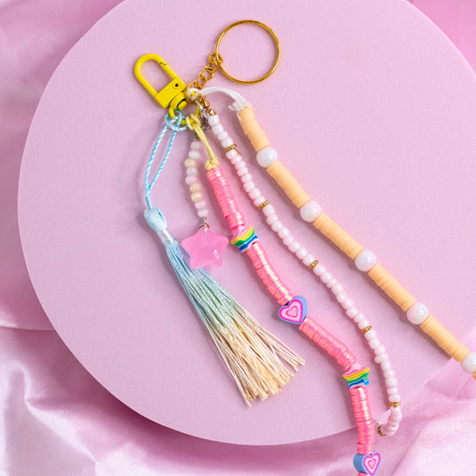 Colorful purse charm with pastel beads, rainbow accents, a pink star charm, and ombré tassel on a yellow clasp.