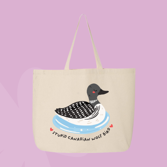 Funny Canadian themed tote bag with illustrated loon floating on water and text reading stupid Canadian wolf bird.