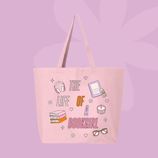 Pink tote bag with colorful pastel doodles of books, headphones, glasses, a candle, and text that says “The Life of a Bookgirl.”