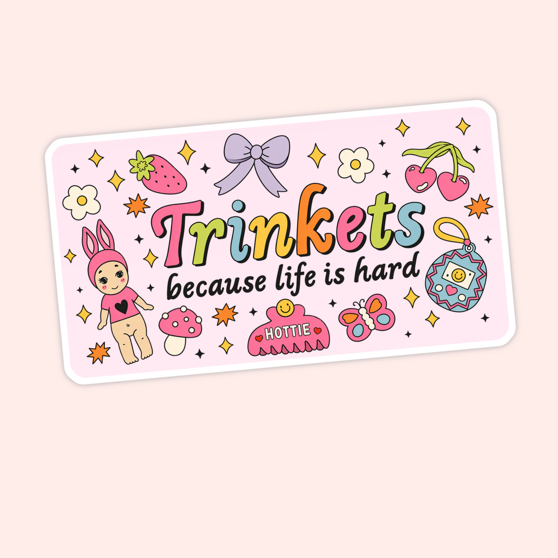 Cute pink sticker that says “Trinkets because life is hard” with colourful doodles including cherries, a bow, strawberry, butterfly, mushroom, and charm.