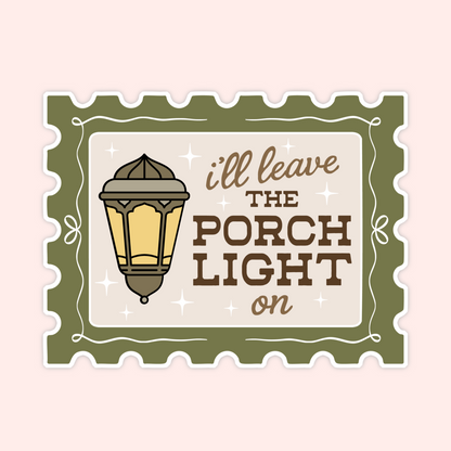 A square decorative sticker or sign with scalloped edges, featuring an illustrated vintage porch light and the phrase “i'll leave THE PORCH LIGHT on” in brown and tan lettering on a cream background, set against a pale pink backdrop.
