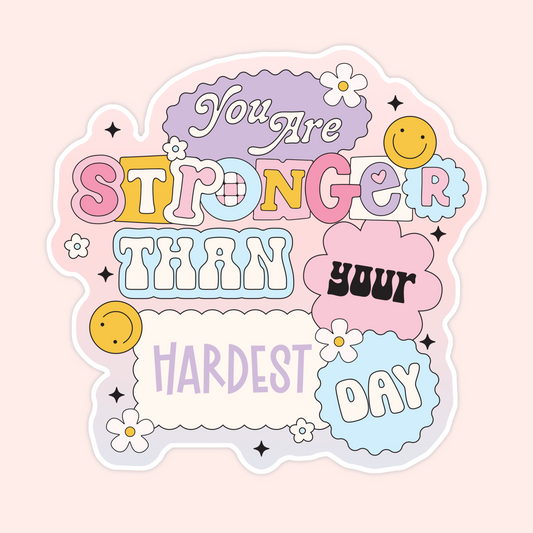 Pastel motivational sticker with playful bubble lettering reading “You’re stronger than your hardest day,” decorated with smiley faces, flowers, and soft retro shapes in pink, yellow, blue, and lavender.