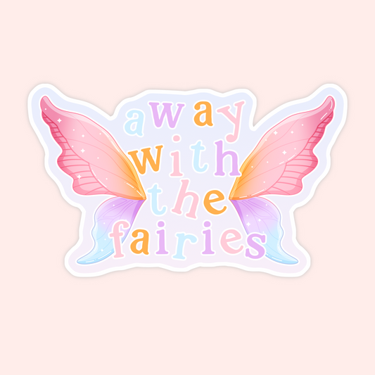 A die-cut sticker featuring pastel-colored fairy wings and the text 'away with the fairies' in soft multicolor lettering, shown on a pale pink background.